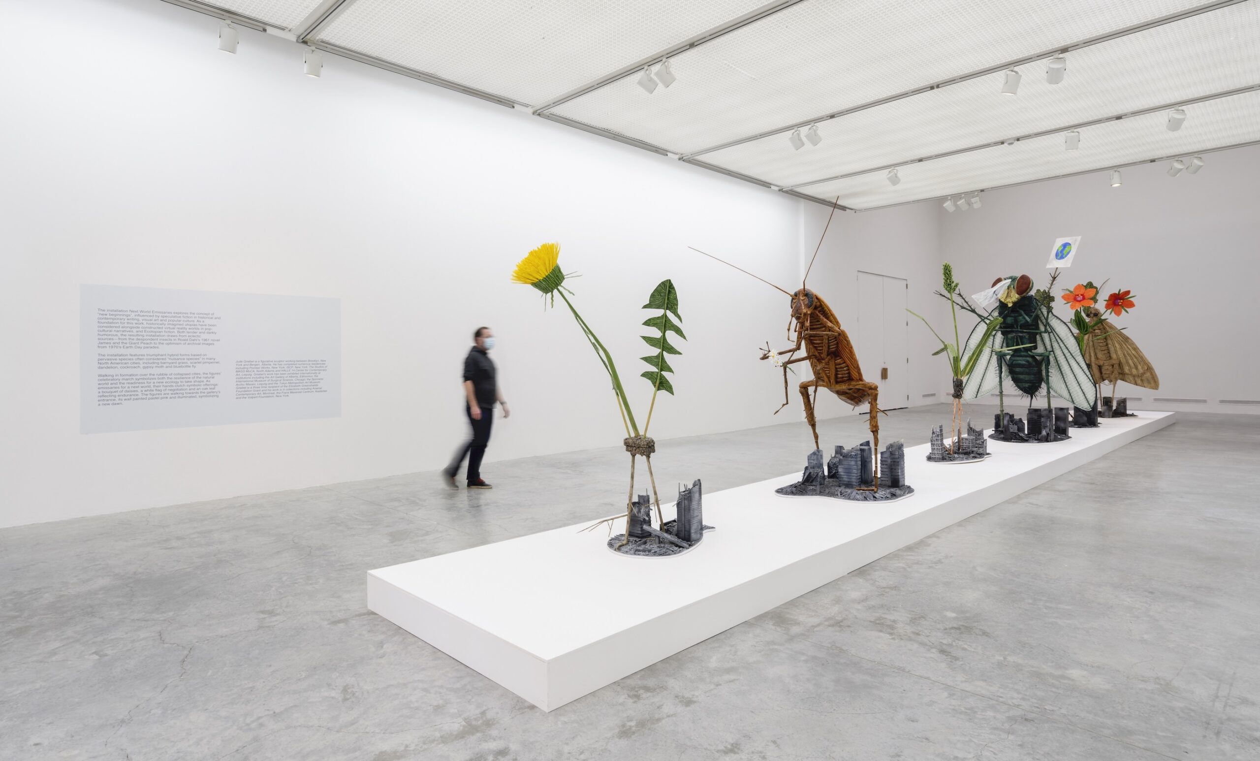 A sculpture of monumental weed and insect species walking over the ruins of a city