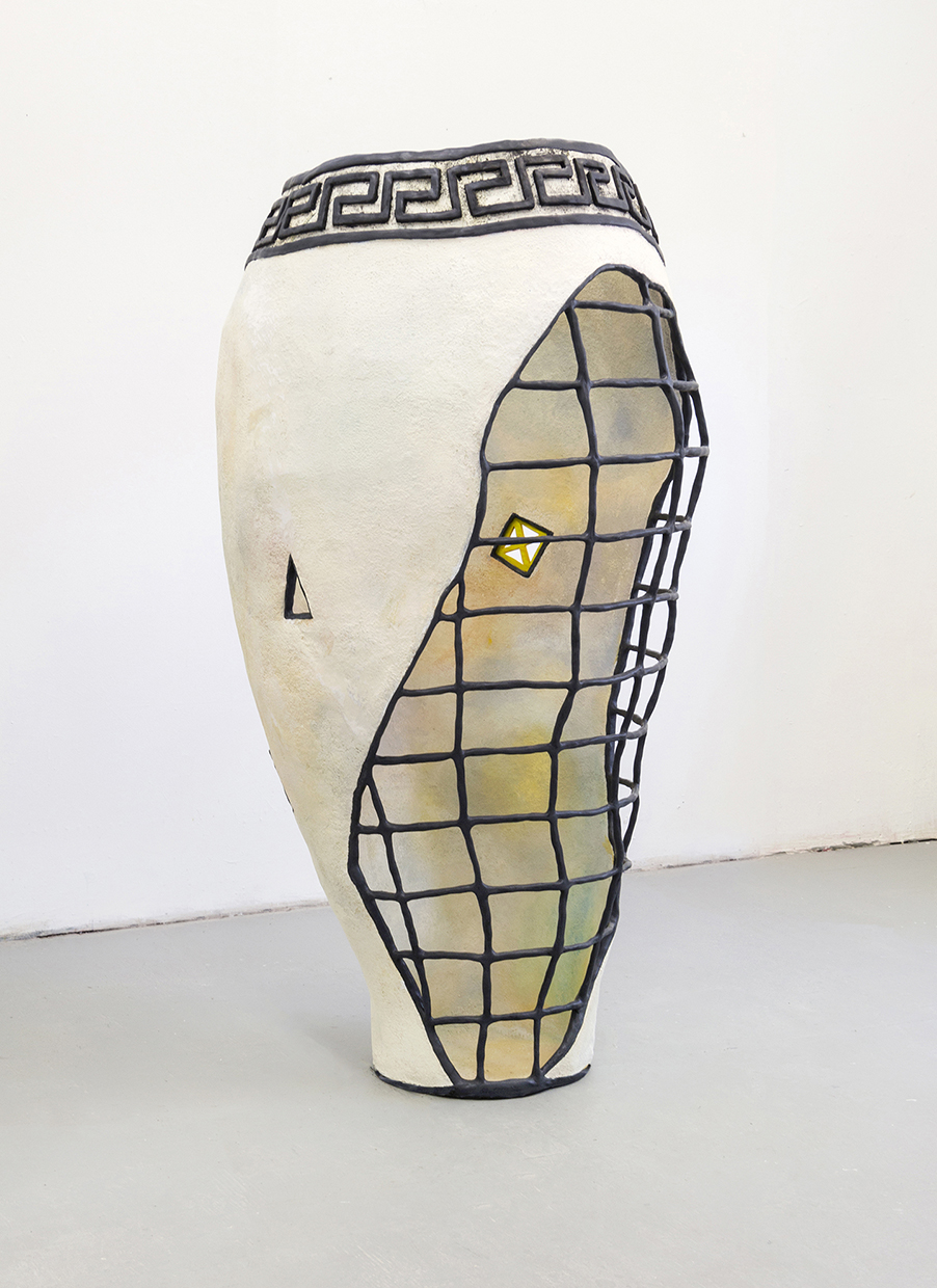 A lifesize off-white vessel with a gritty papery texture, which has a black modelled gridded armature partially exposed. The vessel is not perfectly symmetrical. It undulates in a slightly awkward way. There is a black modelled Greek key design on the exterior of the vessel at the rim which encircles the form. Inside the vessel, a variety of pastel colors are mixed with white paint to create a subtle glowing effect within.