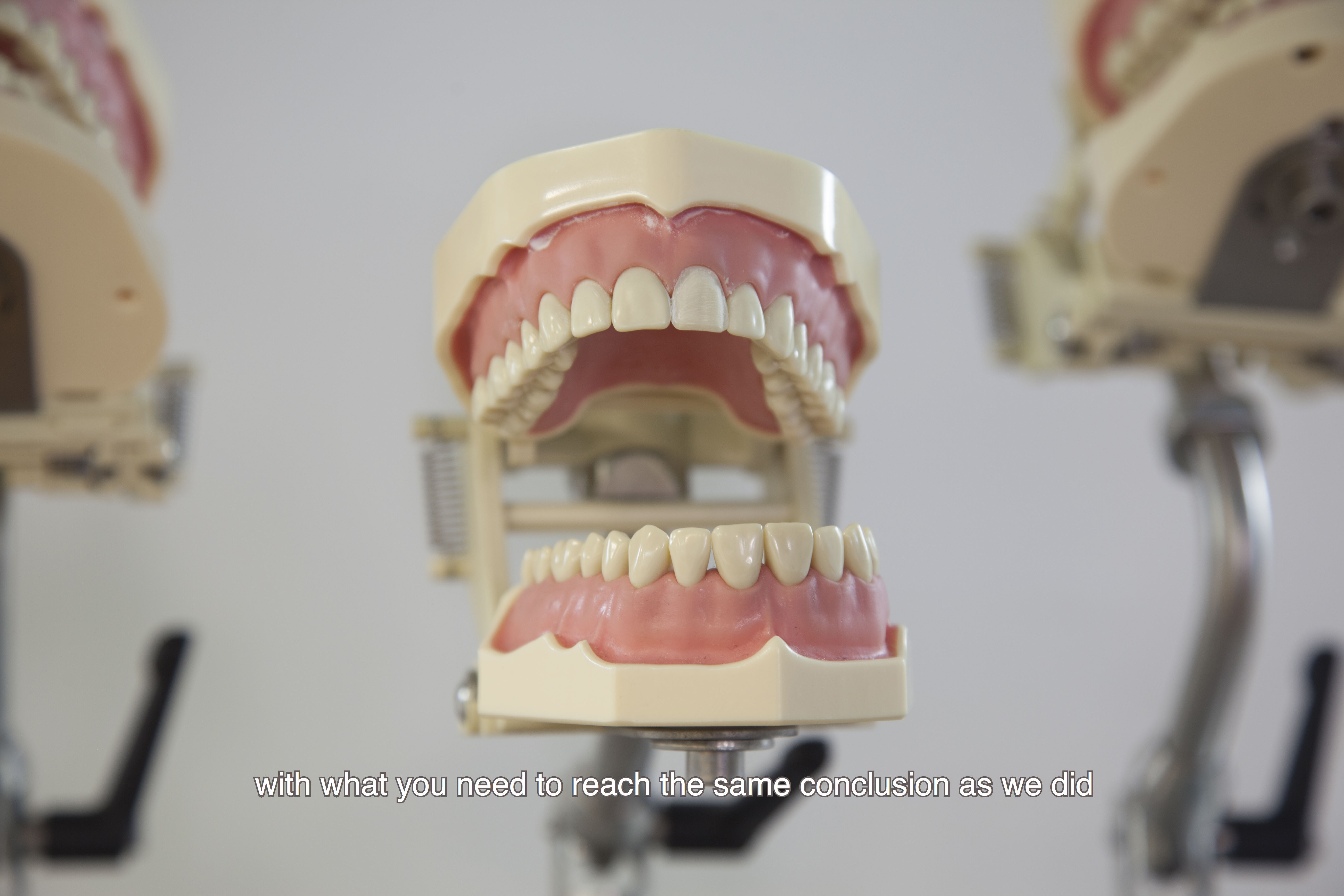 A still shot from the video A Problem, where three dental set jaws give a speech about a problem