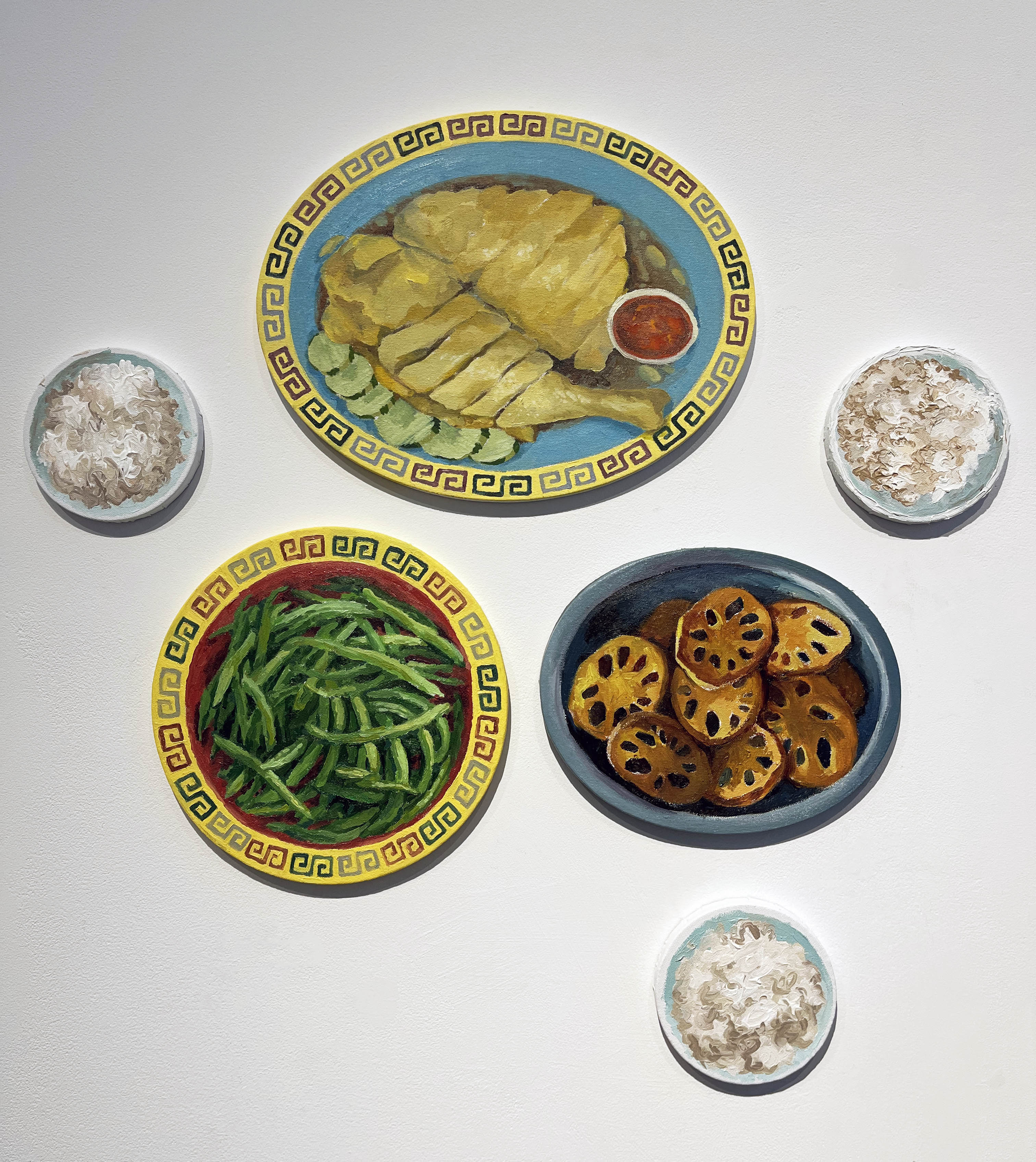 A group of 6 circular paintings, three smaller ones of which depict rice bowls, one larger oval painting of Hainanese chicken with cucumber and sweet and spicy sauce, a larger circle painting of Sichuan dry fried string beans, and a larger oval painting of sauteed lotus root. The paintings are arranged like a family-style meal.