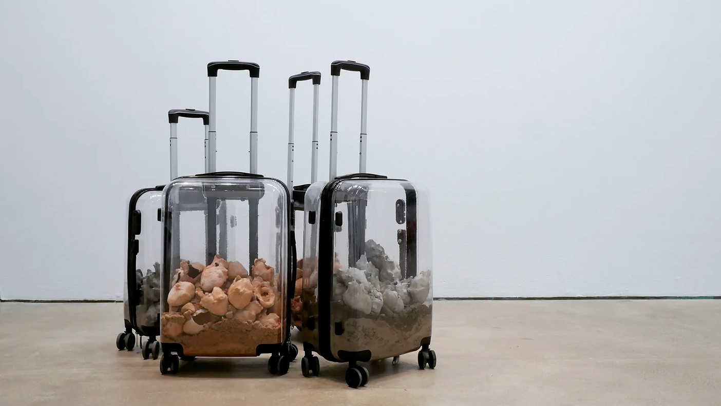 The work consists of four see-through travel suitcases with heart-shaped elements resting inside. The hearts are made of terracotta and porcelain combined with contaminated soil material collected from different sites of Finland and Brazil where mining industry activities has been reported as responsible for environmental contamination.