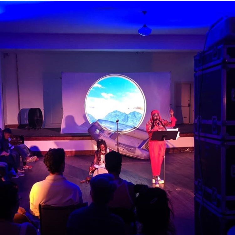 poet performing with musicians and video projections