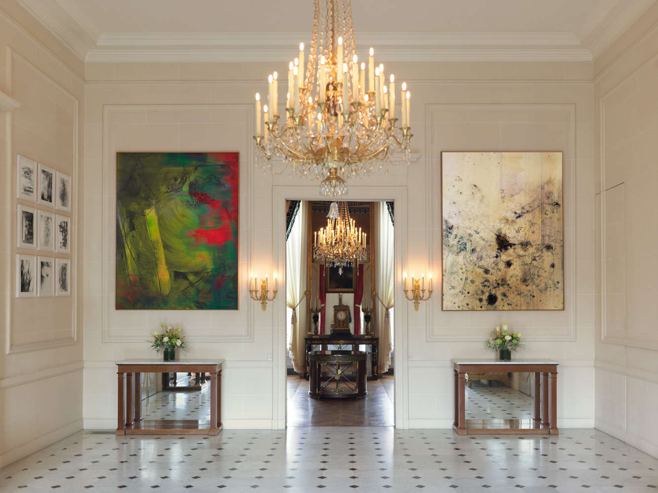 Installation view of a room with a big chandelier, and two large paintings above two small tables. Exhibition “Elias Wessel : La somme de mes données;” Palais Beauharnais Paris, 2020