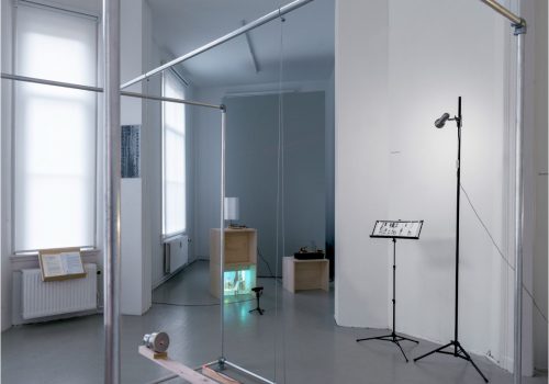 The installation view of two sound-image converts devices and spectrograms for performance. Of those two devices, one is made of a mirror, vibration speaker and laser light and the other is made of a metal cup with a rubber lid and laser lights combined on a flat wooden stick which is hung like a swing.