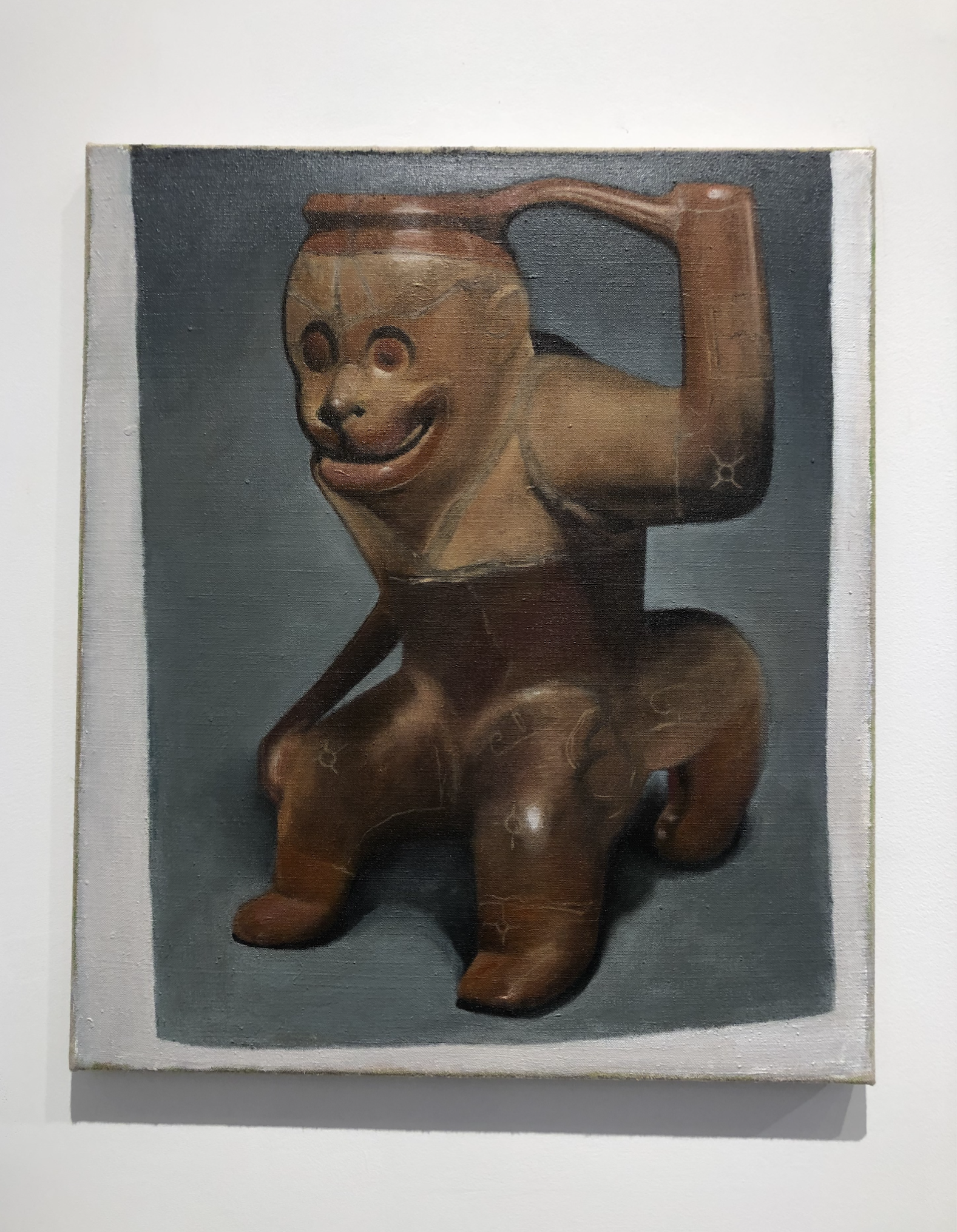 Painting of a page from an archaeology book of Costa Rican ceramics. Depicting a monkey photographed in a studio display.
