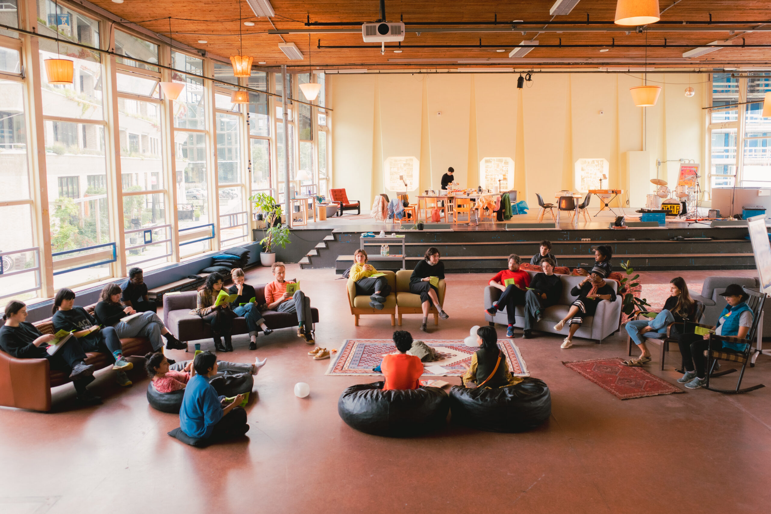 Group of people are gathering in a large yellow living room listening to each other