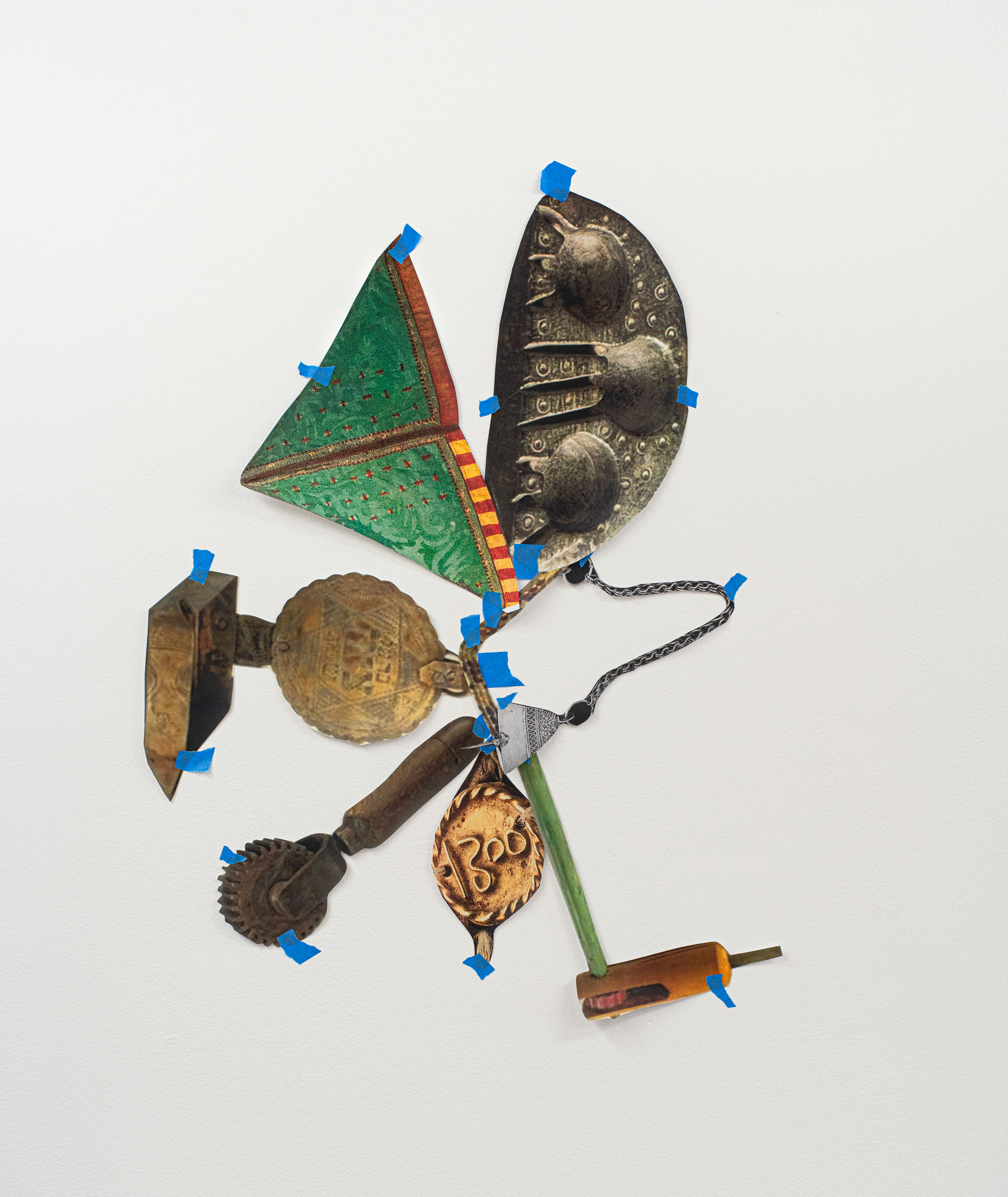 A photographic collage of cutout images - of objects from Morocco, held together to the wall with blue tape