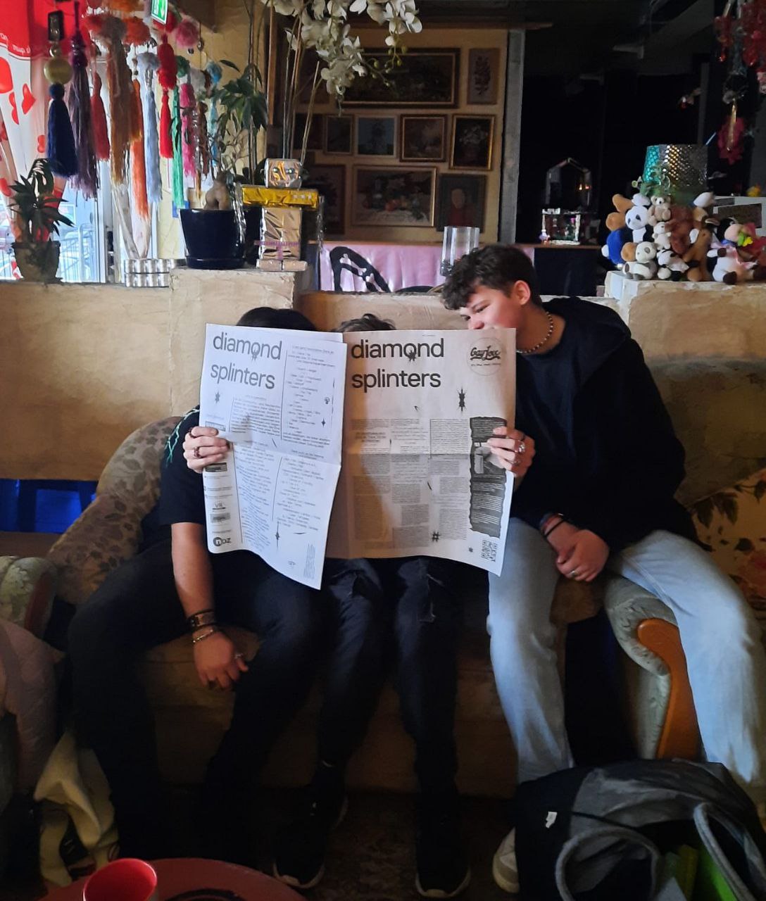 Three teenagers reading a newspaper, showing the title "diamond splinters"